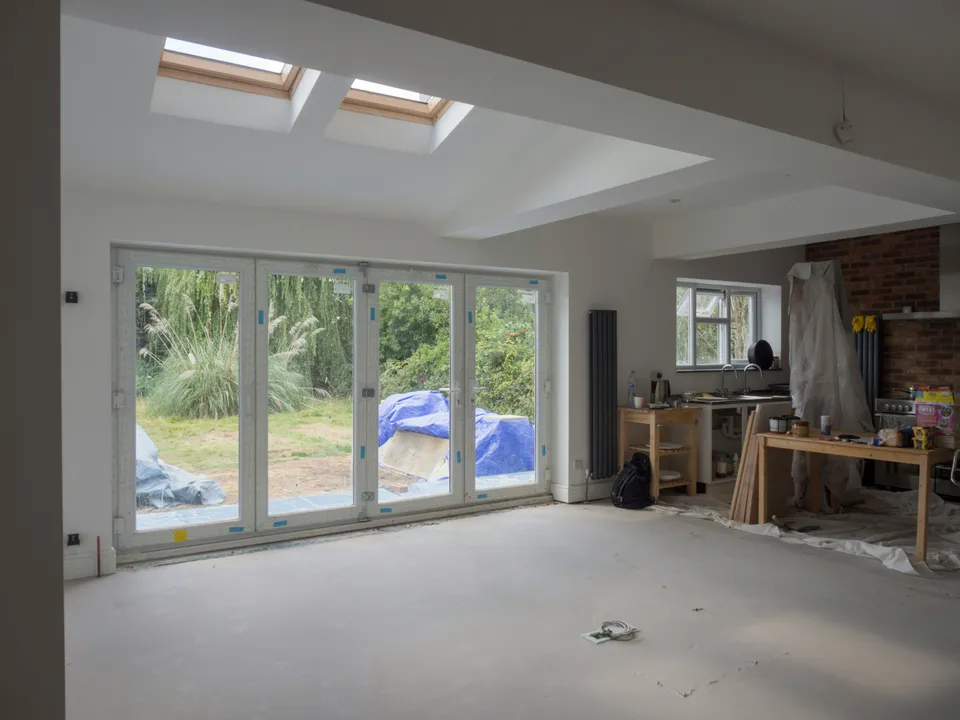 Open-plan room with two roof windows and bi-fold doors onto the garden, floor not yet finished