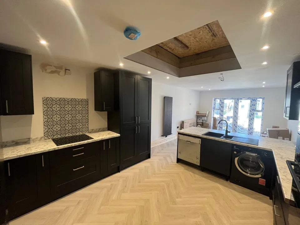 Kitchen run with hob, patterned tile splashback and herringbone floor
