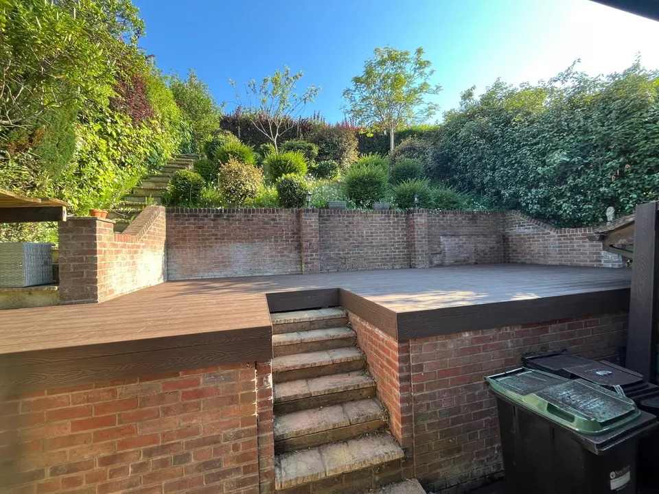 Raised composite deck with brick retaining walls and brick steps