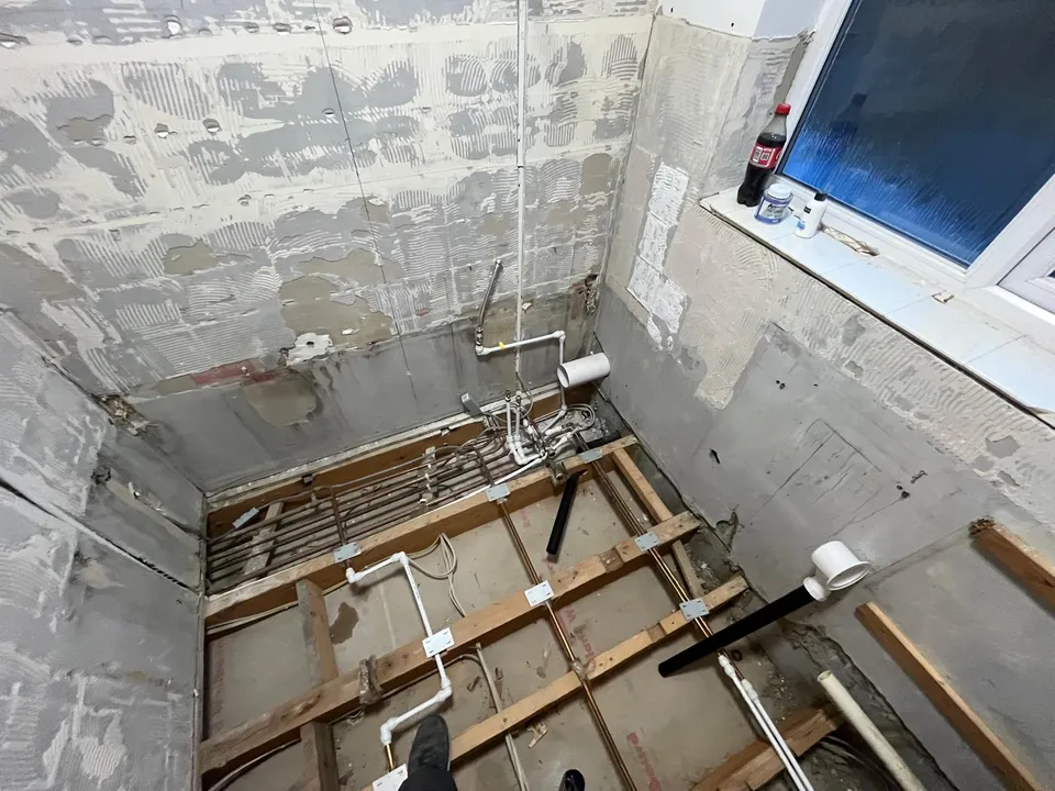 Shower room stripped back to the floor joists and pipework